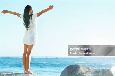 Woman Standing On Beach With Arms Up Rear View Photos And Premium High