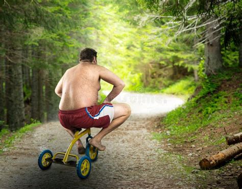 Vuxen Naken Man Som Cyklar På Barns Cykel Arkivfoto Bild av medel