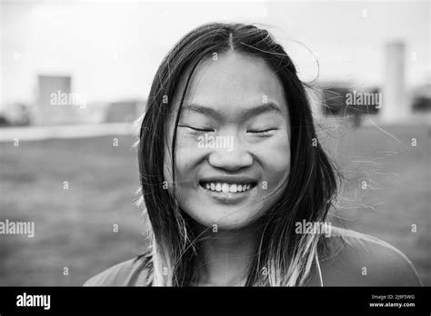 Asian Girl Smiling On Camera At City Park Focus On Face Black And