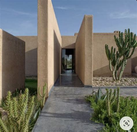 The Entrance To An Adobe Style Building With Cactus Plants