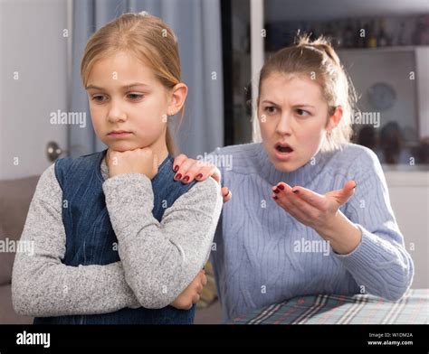 Serious Adult Mother Scolding Her Teenage Daughter At Home Stock Photo