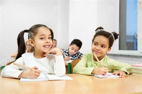 Beautiful Girls Posing In Classroom While Studying At School Stock