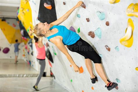 Woman Climbing Tall Indoor Man Made Rock Climbing Wall Stock Image