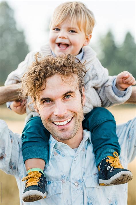 Young Dad Carrying Cute Son On His Shoulders By Stocksy Contributor