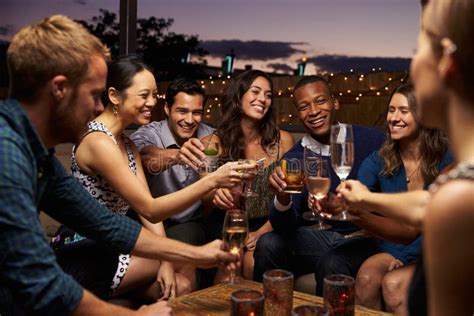 Group Of Friends Enjoying Night Out At Rooftop Bar Stock Image Image