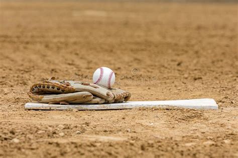 Baseball Glove And Ball On Pitching Mound Rubber On Infield Of Baseball