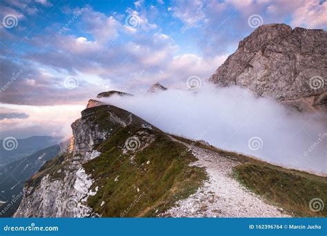 Mangart Mountains Peak Above Clouds At Dramatic Sunset In Julian Alps