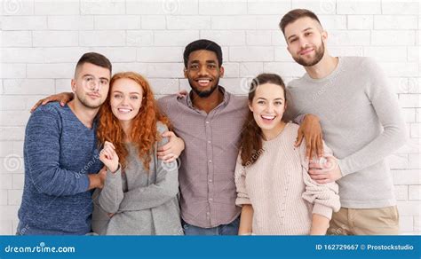 Group Of Happy Friends Embracing And Smiling To Camera Stock Image