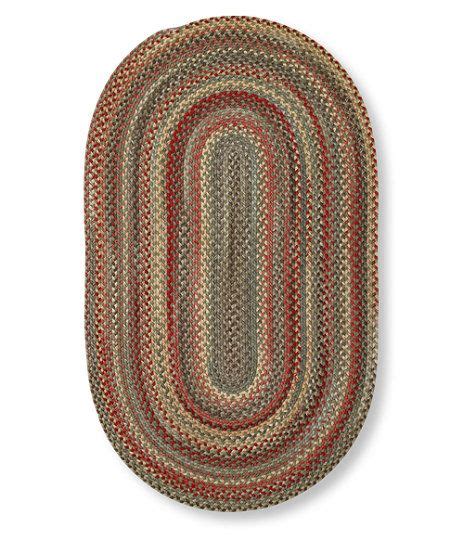 The Oval Rug Is Made From Braided Yarn And Has Red Green Yellow And Beige