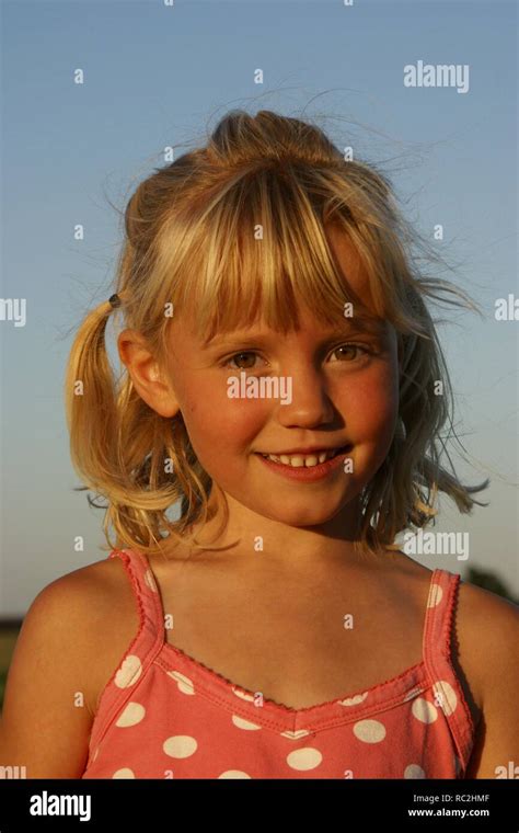 Cute Happy Young Girl Outside Against Blue Sky Look At Camera Blonde Dutch Girl With Hair