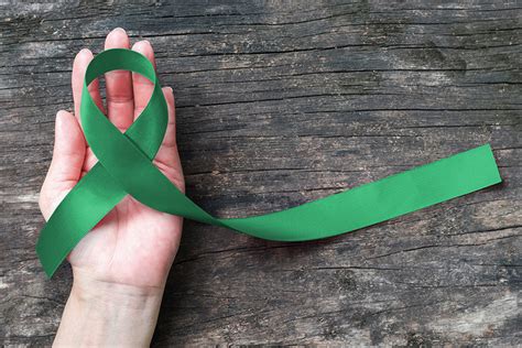 Liver Cancer Awareness Ribbon Emerald Green Color Ribbon On Human Hand
