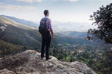 Man Looking Out Over Beautiful Valley From Mountain Peak By Stocksy