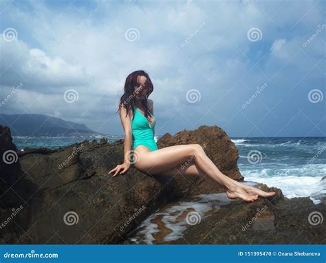 Beautiful Tanned Caucasian Woman Resting On The Rock Sea Beach Crete