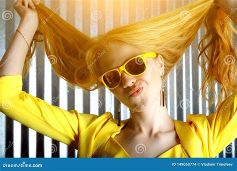 Young Playful Blonde Crazy Girl In Sunglasses With Flying Hair Is