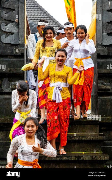 A Group Of Young Balinese Hindu People Leaving A Temple During A Local