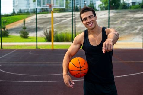 Free Photo Handsome Man Holding A Basketball Ball Medium Shot