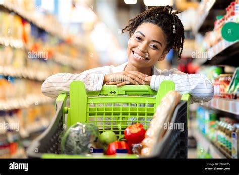 African American Lady Posing With Shop Cart In Supermarket Stock Photo