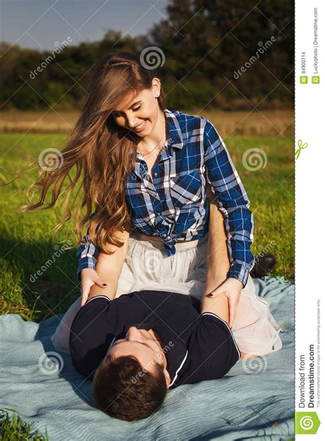 Девушка сидит на парне на пикнике Стоковое Фото изображение насчитывающей парк лужок 84900714