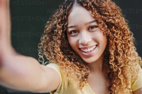 Beautiful Woman With Curly Hair Taking Selfie Stock Photo