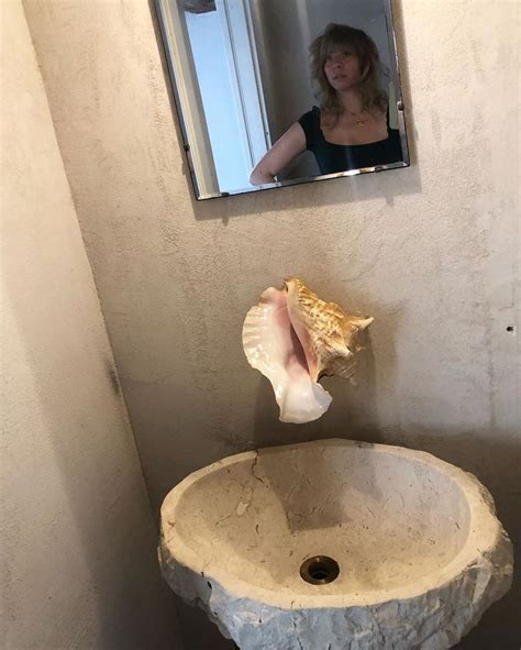 A Woman Is Taking A Selfie In The Bathroom Mirror While Standing Next