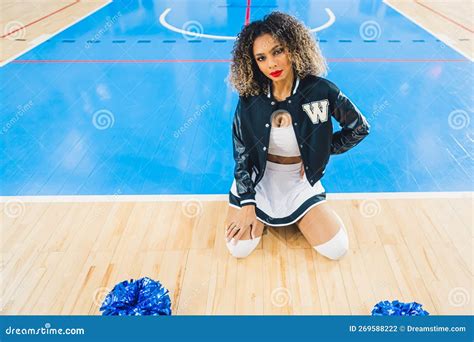 Curly Haired Cheerleader Sitting On Her Knees In The Arena Sports