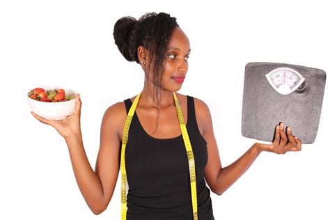 Woman Holding Weight Scale And Bowl Of Fruits