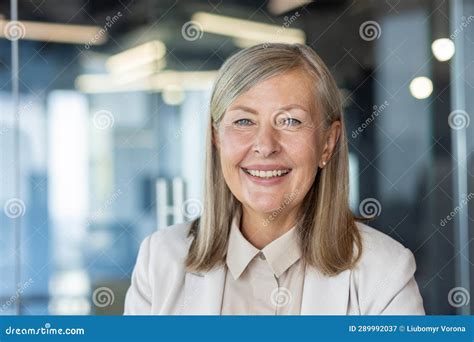 close up portrait of mature gray haired business woman senior adult woman smiling and looking