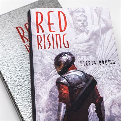 Two Red Rising Books Sitting On Top Of Each Other