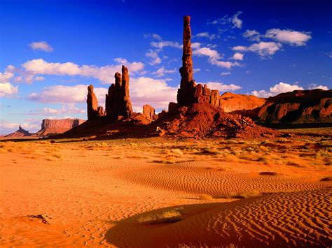 Towers Of Red Rock Desert Area With Red Sand And Rocks Monument Valley