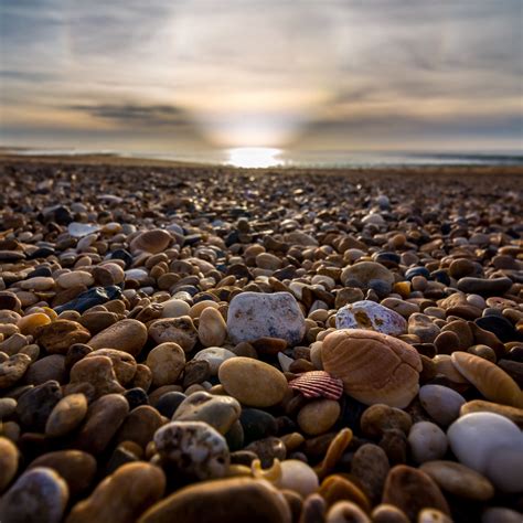 Download Wallpaper 2780x2780 Beach Pebbles Sea Stones Sky Rays