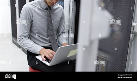 Technician Performing Maintenance Tasks In A Server Room Rack Stock