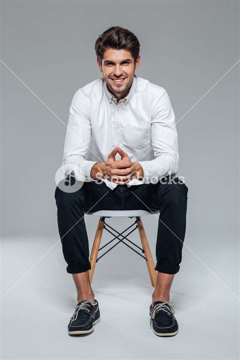 Smiling Happy Handsome Man In White Shirt Sitting On The Chair Over