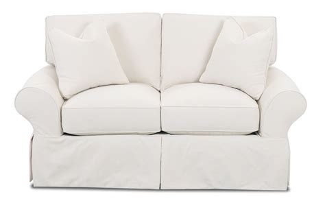 Slipcovered Loveseat With Rolled Arms And Tailored Skirt By Klaussner