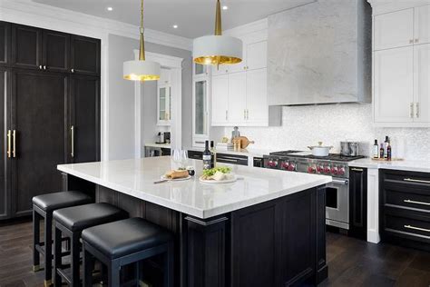 Dark upper cabinets command the wall space while matching dark panels encapsulate the white cabinetry. White and brown kitchen features white upper cabinets and espresso stained lower cabinets ...