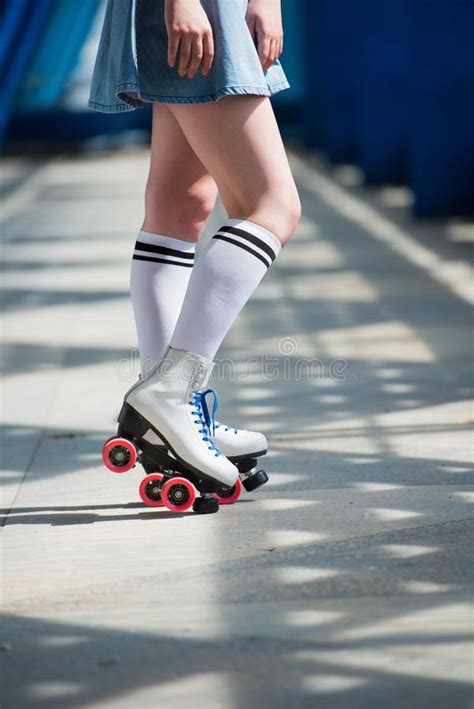 Cropped Shot Of Girl In Denim Skirt And Vintage Roller Skates Stock