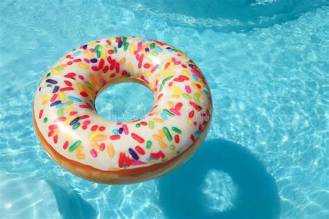 Bright Inflatable Doughnut Ring Floating In Swimming Pool On Sunny Day