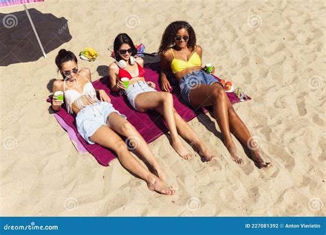 grupo de mujeres jóvenes descansando en la playa tomando el sol en un día de verano brillante