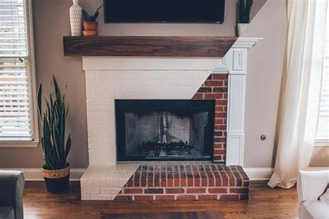 We drilled a few holes through the wood into the mortar using a masonry drill bit. White Brick Modern Fireplace #brick #diy #mantel # ...