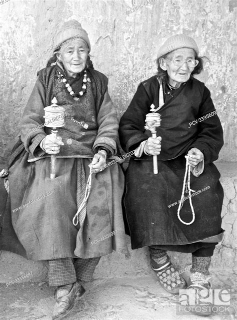 Senior Female Pilgrims In Traditional Tibetan Dress With Prayer Wheels