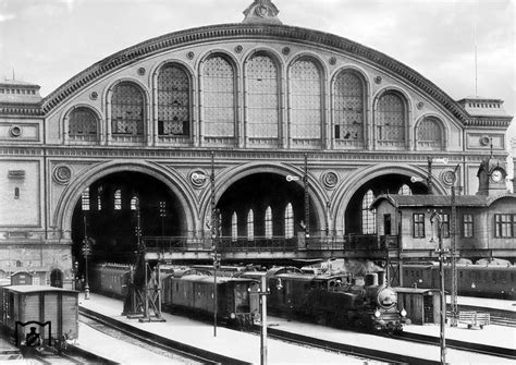 Black And White Photograph Of An Old Train Station With Trains Parked