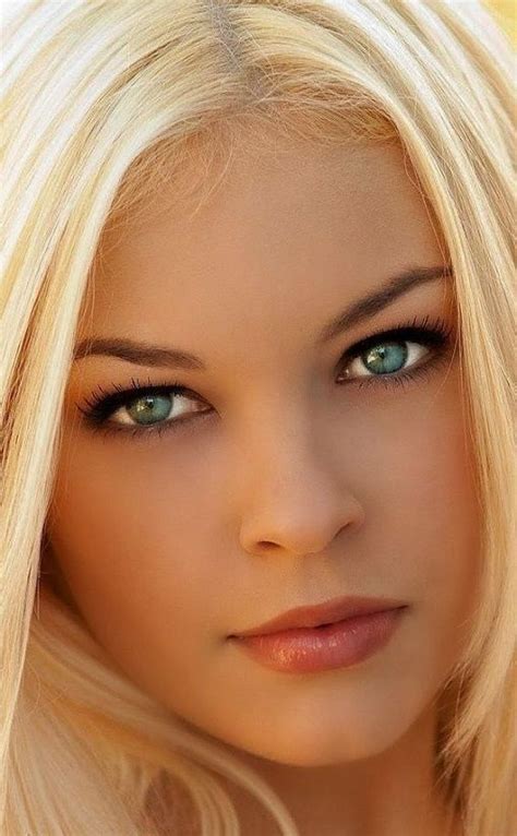 A Woman With Long Blonde Hair And Green Eyes