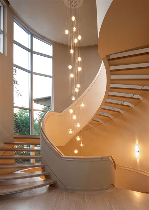 A Spiral Staircase With Lights Hanging From It