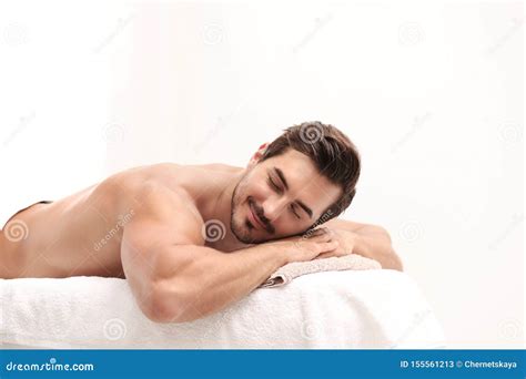 Handsome Young Man Relaxing On Massage Against Light Background Space