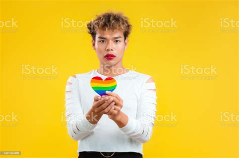 Hopeful Young Asian Gay Man Holding Rainbow Paper Cut Heart In Concept