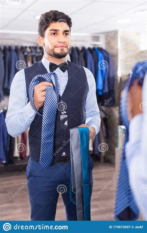 El Hombre Está Cogiendo Corbata Para Un Chaleco Frente Al Espejo Imagen de archivo Imagen de