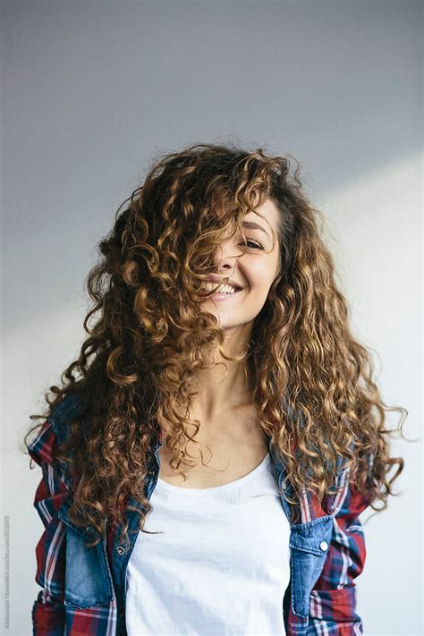 Portrait Of Beautiful Young Woman With Curly Hair Laughing At Camera