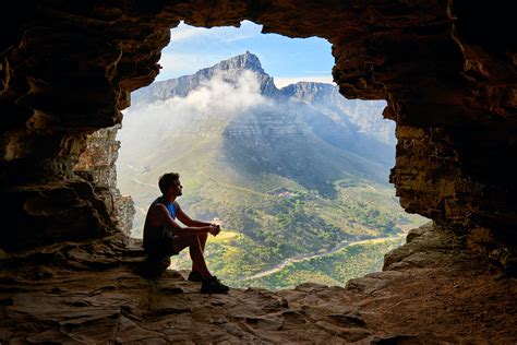 Photo Of Man Sitting On A Cave · Free Stock Photo