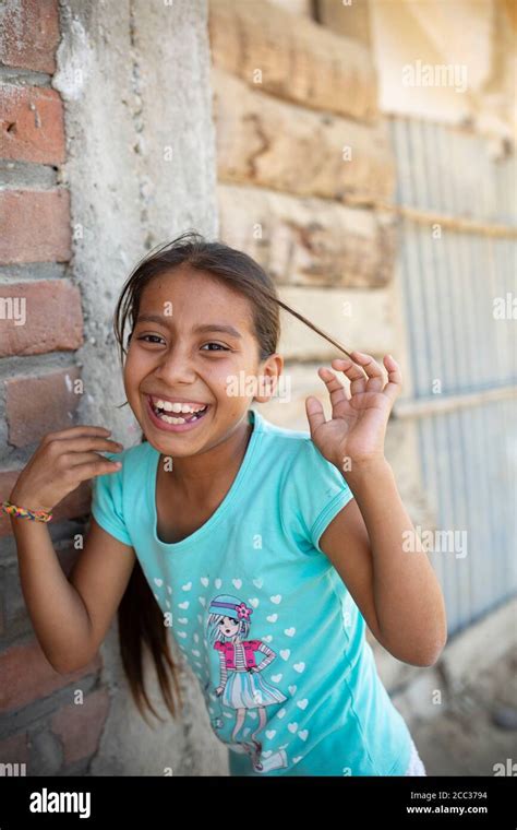 A Ten Year Old Latina Girl Smiles Outside Her Home In Sullana Peru