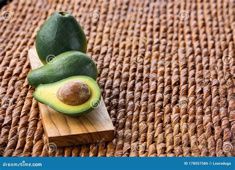 Three Ripe Avocados On Wooden Background Two Whole And One Cut Stock