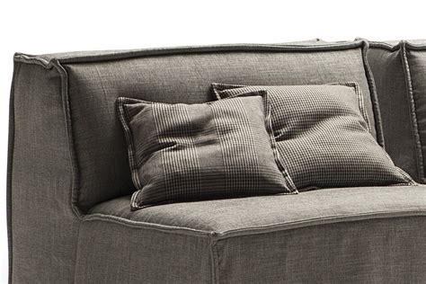Il divano poggia su un'elegante base in alluminio pressofuso verniciato nei colori grigio e bronzo, oppure satinato, cromato, brunito, cromo nero e champagne. Cuscini decorativi e d'arredo quadrati